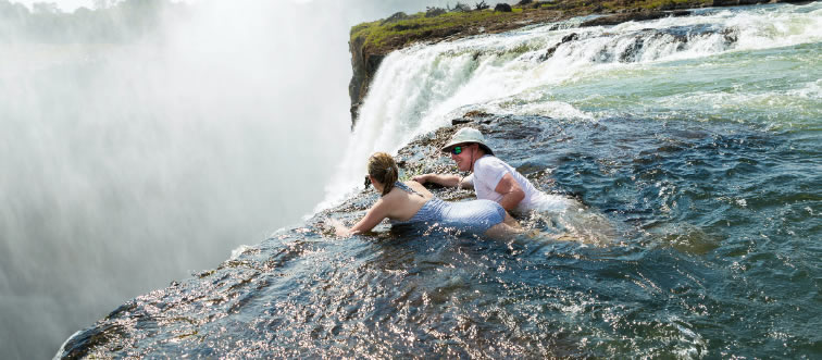Which iconic cascade serves as the natural boundary between Zambia and Zimbabwe?